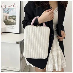 Detailed view of quilted laptop sleeve with pink handles and sturdy metal zippers