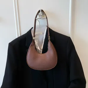 Dark brown crescent hobo bag with pebble leather texture and gold metal hardware