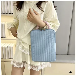 Close-up of quilted light blue laptop bag with pink handles and double zipper detail