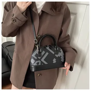 Detail of vintage shell handbag featuring gray geometric patterns and gold metal buckles