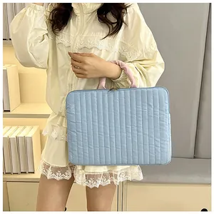 Vertical quilted laptop sleeve in sky blue with light pink handle and dual zippers
