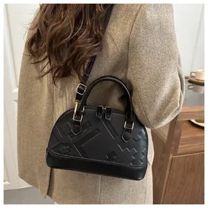 Side view of black shell bag with pebble leather and geometric embossing on coat