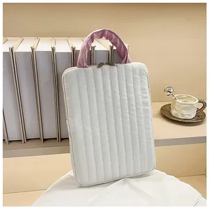 Close-up of quilted tablet sleeve with pink handles and dual metal zippers in soft setup
