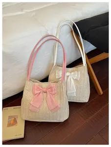 Detail of woven tote bags with large chiffon bows in pink and white beach style