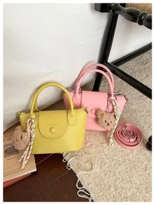 Mini lychee leather handbag detail with cute bear pendant and detachable shoulder strap