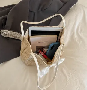Detail view of straw tote bag interior capacity with tablet, phone, and makeup