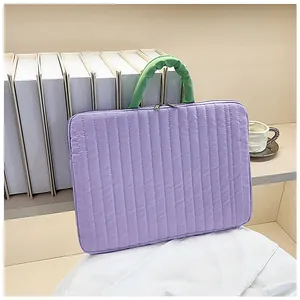 Detail of lavender quilted laptop sleeve with green ruched handles and dual zippers