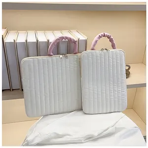 Detail of quilted laptop sleeves in two sizes with pink handles and dual metal zippers