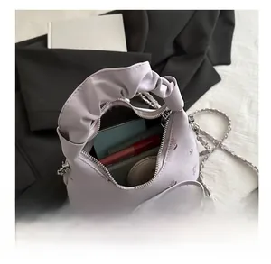Vue détaillée du sac à main plissé lilas fleuri montrant la capacité pour le maquillage