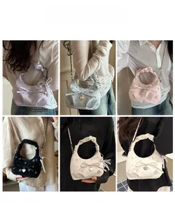 Détail du sac à main fleuri avec poignée plissée, nœud élégant et pendentif cœur