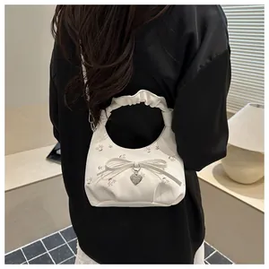 Détail du sac blanc à fleurs avec poignée plissée, nœud élégant et pendentif cœur