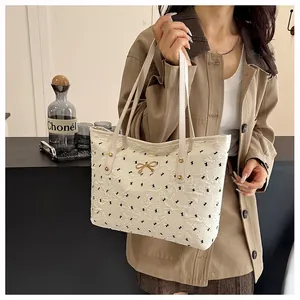 Sac fourre-tout crème chic avec texture matelassée et broderie de nœuds noirs