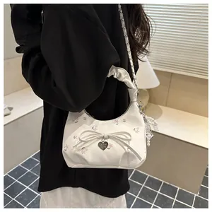 Détail du sac à main blanc fleuri avec nœud 3D, pendentif cœur et bandoulière en perles