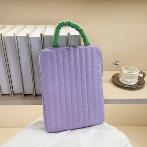 Quilted purple laptop sleeve with green scrunchie handle for tablet storage