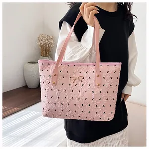 Détail du sac cabas rose avec texture plissée, nœud doré et poignée en cuir