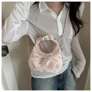 Vue détaillée du sac floral rose avec poignée plissée et pendentif coeur en métal