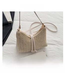 Dettaglio della borsa di paglia beige con trama intrecciata e confronto con un cellulare