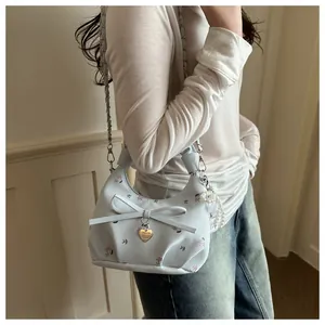 Vue détaillée du sac floral avec nœud, pendentif cœur et bandoulière en perles