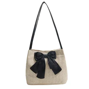 Summer woven shoulder bag in beige with a large black bow and slim strap detail