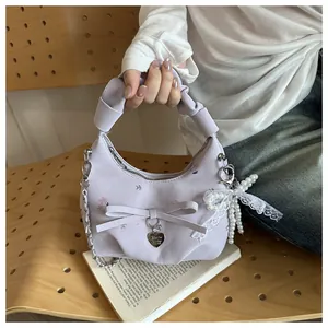 Détail du sac à main plissé violet clair avec imprimés floraux et pendentif en métal