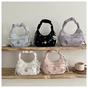 Détail de sacs hobo à fleurs en plusieurs couleurs avec perles et breloques en cœur
