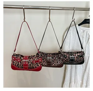Detailed close-up of leopard print shoulder bags with red and black leather buckle accents