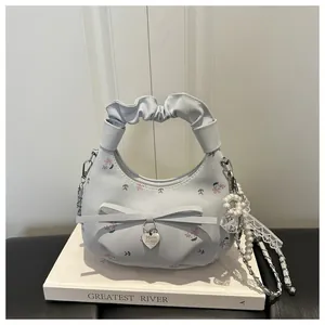 Détail du sac à main bleu clair à fleurs avec perles, anse plissée et dentelle fine