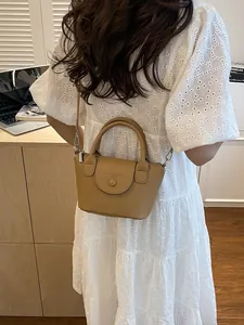 Brown lychee leather mini crossbody bag for women in a cozy lifestyle indoor setting