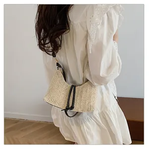 Dettaglio della borsa hobo intrecciata a mano con tracolla in pelle nera e fibra naturale