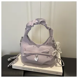 Détail du sac hobo lavande avec imprimés floraux, breloque perle et anse plissée