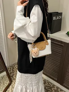 Trendy spring shoulder bag with brown and white color stitching and bear charm