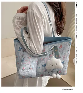 Detail view of a floral tote bag featuring a cloud plush charm and matching pouch