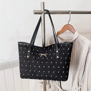 Grand sac cabas noir avec imprimés nœuds blancs et boucle dorée pour mode estivale