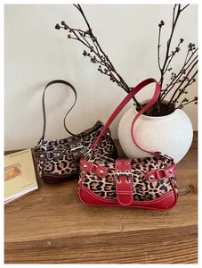 Close-up of leopard print shoulder bags with vintage buckles and metal eyelets