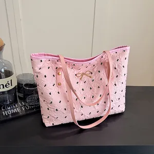 Sac fourre-tout plissé rose avec imprimé nœud noir et ornement de nœud doré élégant