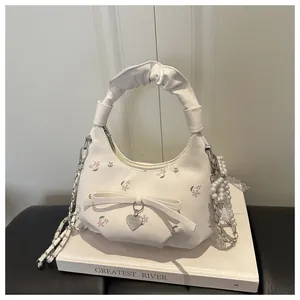 Détail du sac à main plissé floral avec anse en perles et pendentif cœur