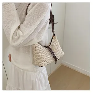 Elegante borsa a tracolla intrecciata con cinturino in pelle marrone su modella