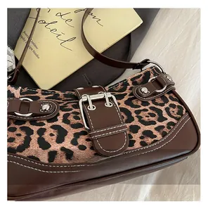 Close-up of leopard print fabric bag with vintage silver buckle and rivet details