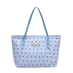 Grand sac cabas bleu clair avec motifs nœuds noirs et décoration nœud en métal doré