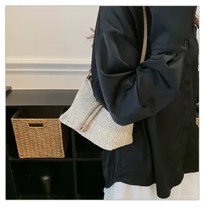 Dettaglio della borsa a spalla in paglia intrecciata con tracolla in pelle e coulisse