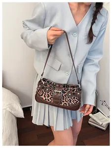 Detail view of leopard print shoulder bag with vintage buckle and silver studs