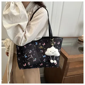 Floral tote bag set with matching pouch and white cloud charm shown on shoulder