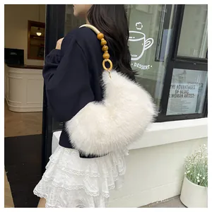 Detail of white faux fur shoulder bag with decorative yellow wooden bead strap