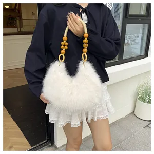 Detail of white faux fur handbag with natural wooden bead handles on a street background