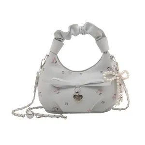 Sac à main bleu clair avec imprimé fleuri, fronces et détail de nœud en perles