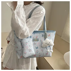 Detailed shot of floral tote bag with mini pouch and white cloud plush charm