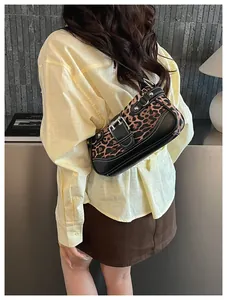 Detail view of the leopard print shoulder bag with silver buckle and rivet accents