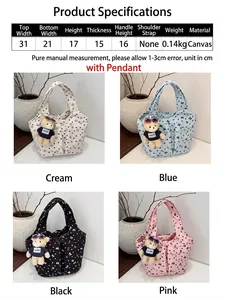 Detalle de bolsos tipo cubo de lona floral con colgantes de oso en varios colores