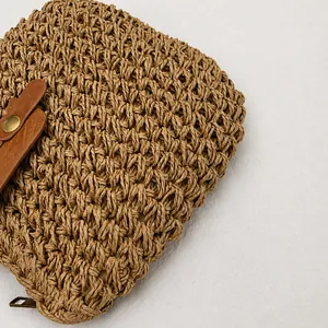 Detail van het strakke papierkoordvlechtwerk en de leren bies op de strandemmer tas