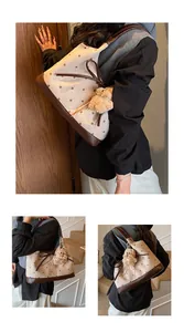 Close-up of polka dot tote bag with brown leather details and a cute plush puppy charm